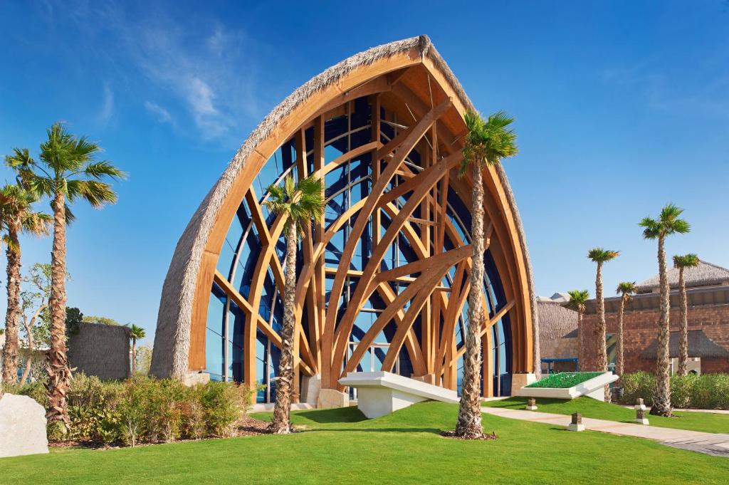 The arched timber-and-glass entrance of Banana Island Resort, framed by palms