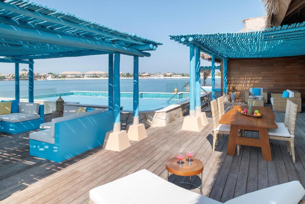 A shaded villa deck with daybeds looking out to sea